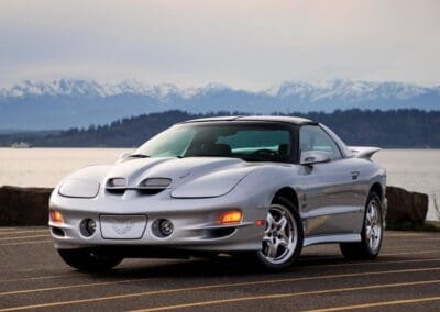 I bought the Firebird in 2007 with only around 700 miles on it, a dream come true since I'd been a huge fan of Firebirds since the Burt Reynolds movies. Most of the mods I've done to the car are cosmetic with some chrome lettering on the rear and chrome grills. My Dad and I also installed a circuit for sequenced rear indicator lights together one time when he visited here from England. The only performance upgrade installed is an SLP airbox lid since it's easy to do. I sprayed it silver to match the car, and finished it with a Firebird decal. I've been going to Shoreline Cars and Coffee for years with my Firebird and met Alex Kwanton there who is an author for Hagerty and Forbes magazine amongst others. He interviewed me and took pictures of my car for an article in Forbes. The pictures shown here are taken by him and included with his permission.